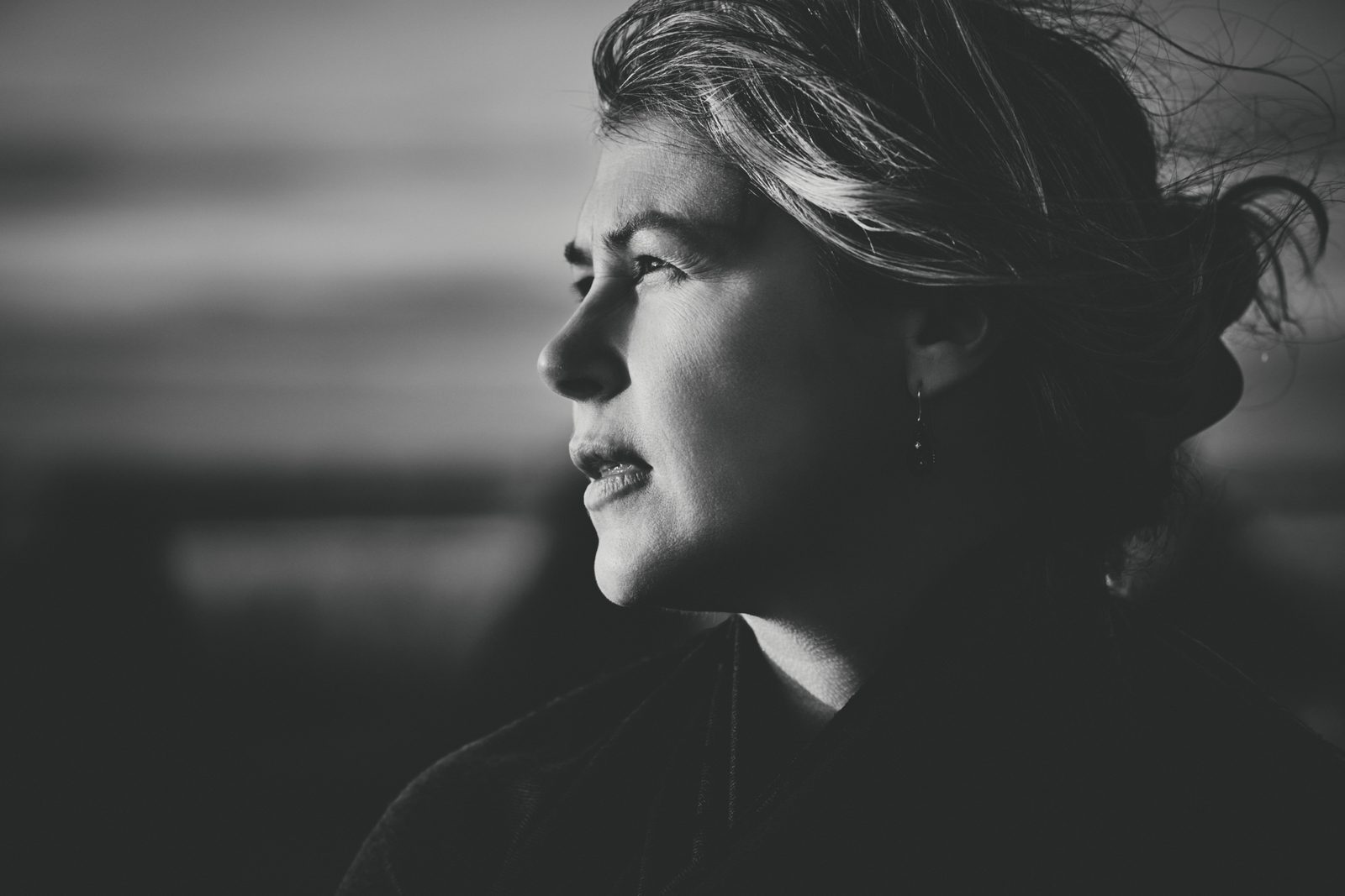 Windblown profile portrait at dusk, black and white portrait photography, Ale’s Stenar, Kåseberga, Sweden, 2026
